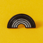 Enamel Black Rainbow pin. Measures approx. 2.5cm.