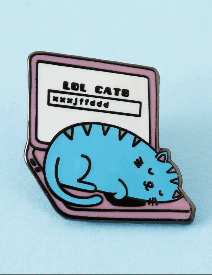 Enamel pin badge featuring an adorable cat sat on the keyboard of a laptop.